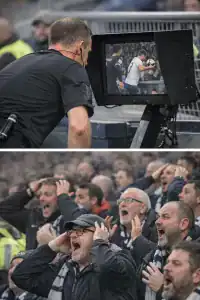 Referee reviewing handball decision during a football match.